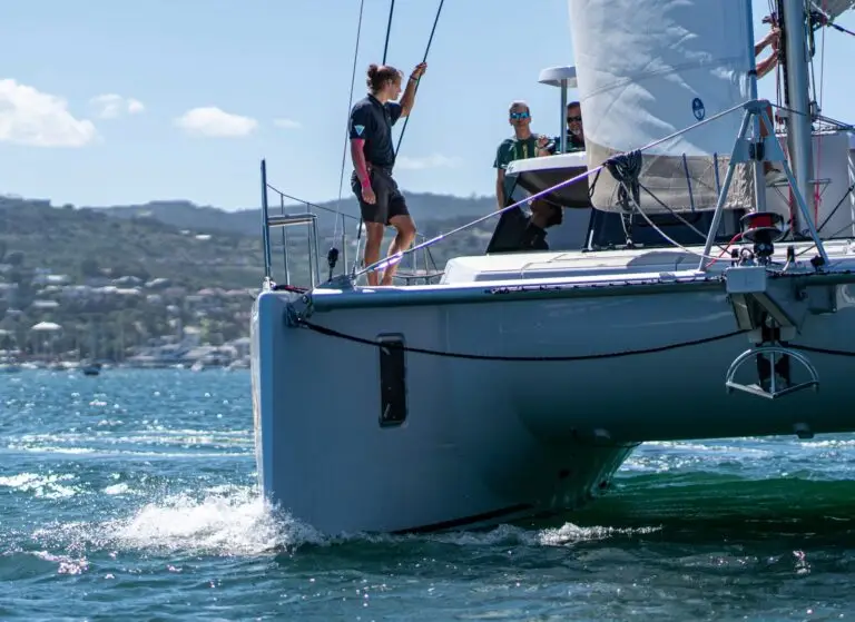 Crew raising the sail on a catamaran